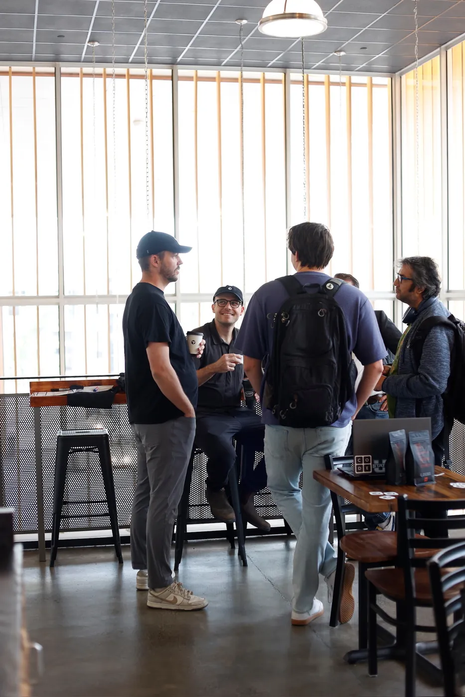 Will Rowston talking with attendees in a cafe-style area at a Cursor event